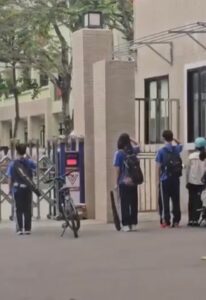 Nhóm học sinh tự giác chào cờ trước khi vào trường, dù đến muộn